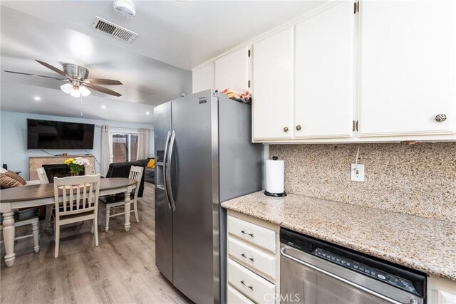 kitchen with a fireplace, light hardwood / wood-style flooring, stainless steel appliances, white cabinetry, and ceiling fan