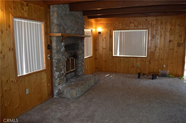 unfurnished living room with wood walls, carpet flooring, and beam ceiling