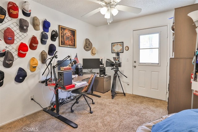 carpeted home office featuring ceiling fan and a textured ceiling