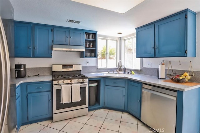 kitchen featuring blue cabinetry, light tile patterned floors, sink, and appliances with stainless steel finishes