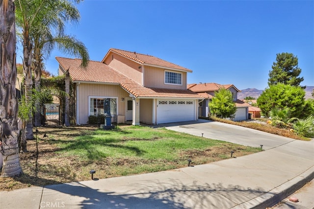 view of front of house with a mountain view, a front lawn, and a garage