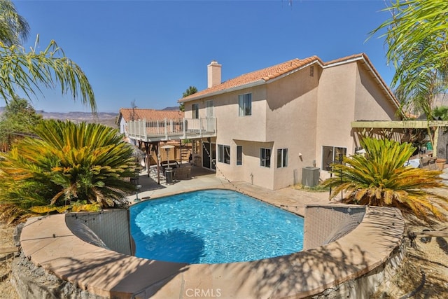 view of swimming pool featuring a patio, central AC unit, and a wooden deck