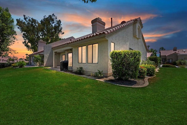 back house at dusk with a yard