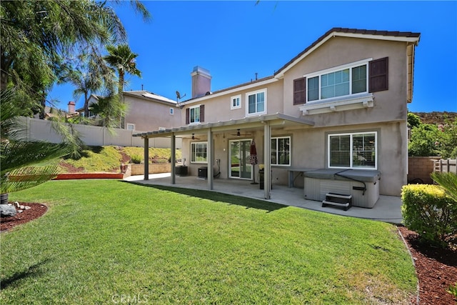 rear view of house featuring a pergola, a yard, a hot tub, and a patio area