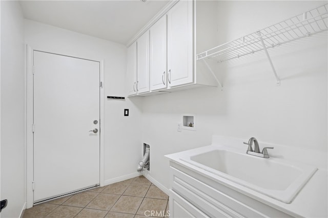 clothes washing area featuring hookup for a washing machine, cabinets, sink, and light tile patterned flooring