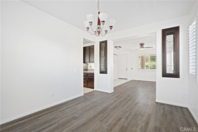 interior space featuring ceiling fan with notable chandelier and dark hardwood / wood-style floors