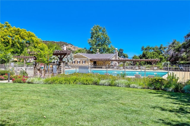 view of pool featuring a lawn