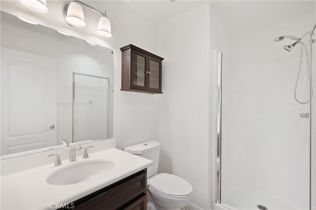 bathroom featuring vanity, toilet, and a shower with door