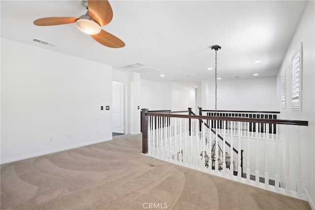 hallway featuring light colored carpet