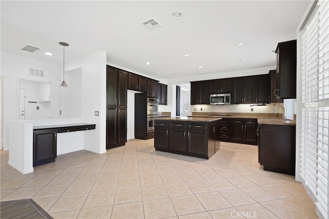 kitchen featuring dark brown cabinets, decorative light fixtures, light tile patterned flooring, and stainless steel appliances