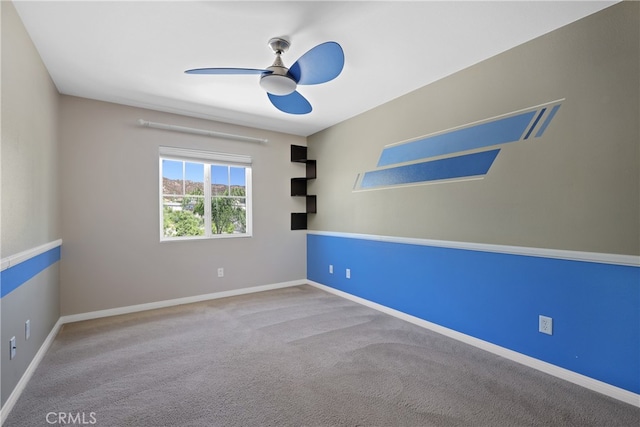 carpeted spare room featuring ceiling fan