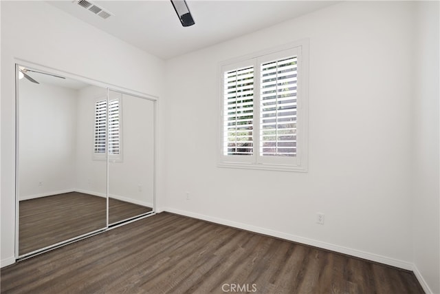 unfurnished bedroom with a closet, ceiling fan, and dark hardwood / wood-style floors