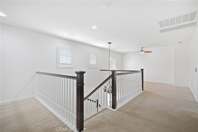 corridor featuring light colored carpet