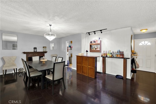 dining room with a chandelier, a textured ceiling, and dark wood-type flooring