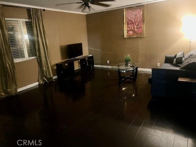 living room featuring dark hardwood / wood-style floors, ceiling fan, and crown molding