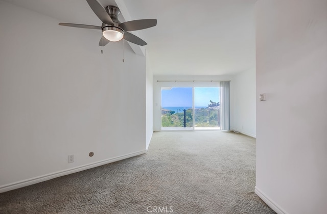 carpeted spare room featuring baseboards and ceiling fan