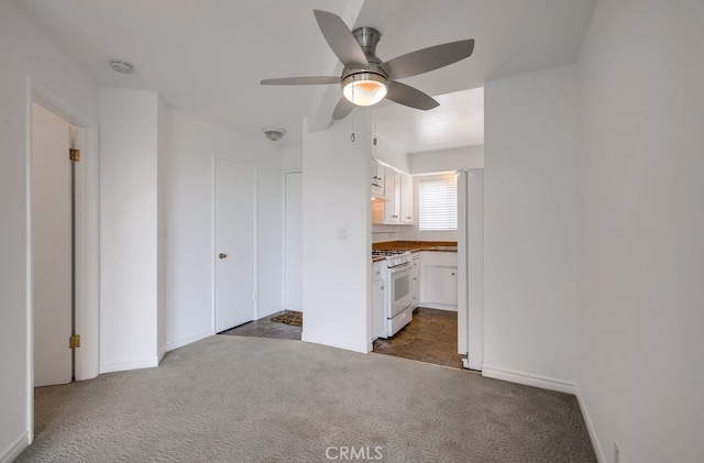 unfurnished living room with ceiling fan and dark colored carpet