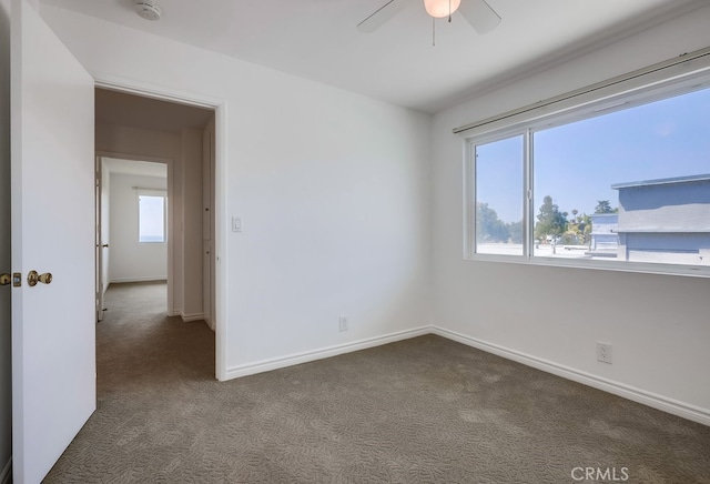 carpeted spare room featuring ceiling fan