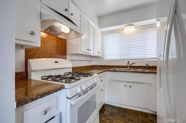 kitchen featuring white appliances, dark countertops, under cabinet range hood, and a sink