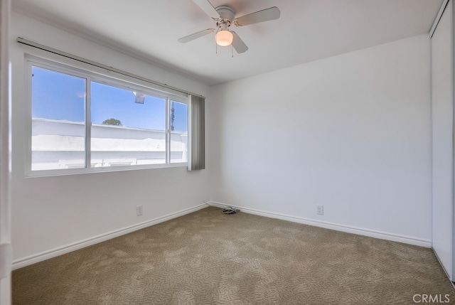 carpeted empty room with baseboards and ceiling fan