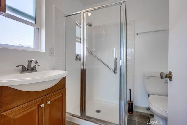 bathroom featuring a shower with shower door, tile patterned floors, toilet, and vanity