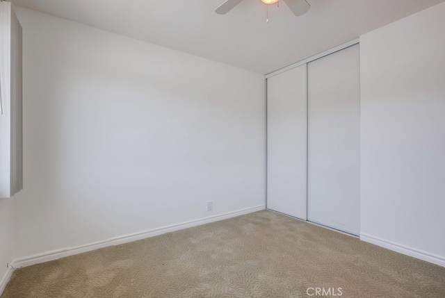 unfurnished room with ceiling fan and light carpet