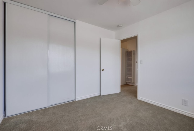 unfurnished bedroom featuring ceiling fan, a closet, and carpet