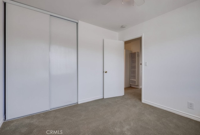 unfurnished bedroom featuring carpet flooring, a ceiling fan, baseboards, and a closet