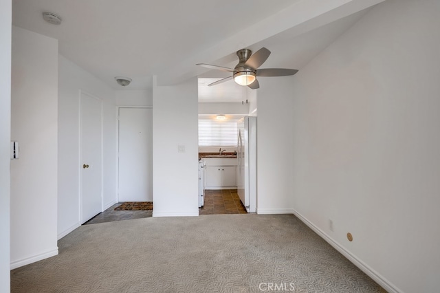 unfurnished bedroom with ceiling fan, dark carpet, and sink