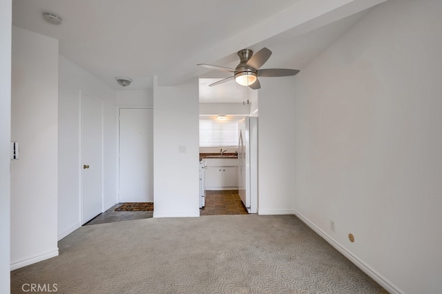 unfurnished bedroom with baseboards, carpet floors, a sink, connected bathroom, and freestanding refrigerator