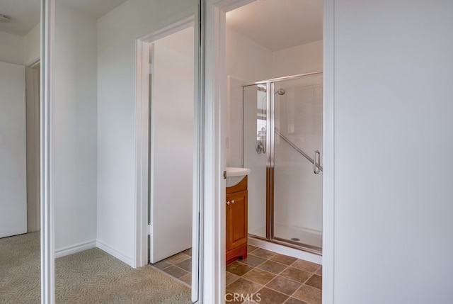 bathroom with vanity and a shower with door