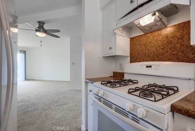 kitchen with white appliances, white cabinetry, ventilation hood, ceiling fan, and light colored carpet