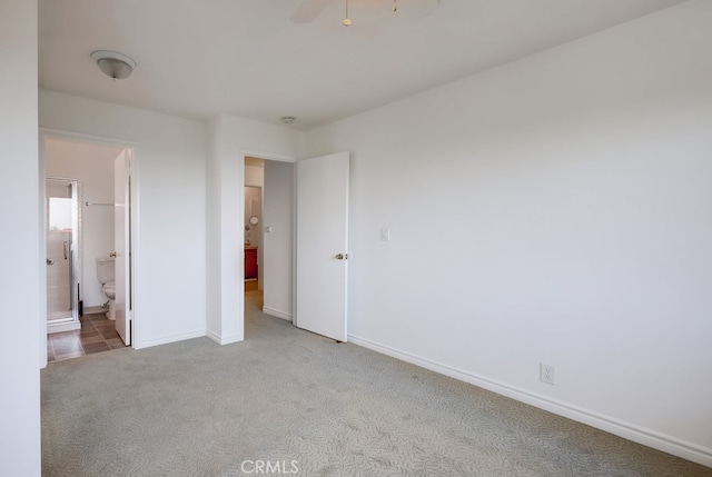 unfurnished bedroom with light colored carpet and connected bathroom