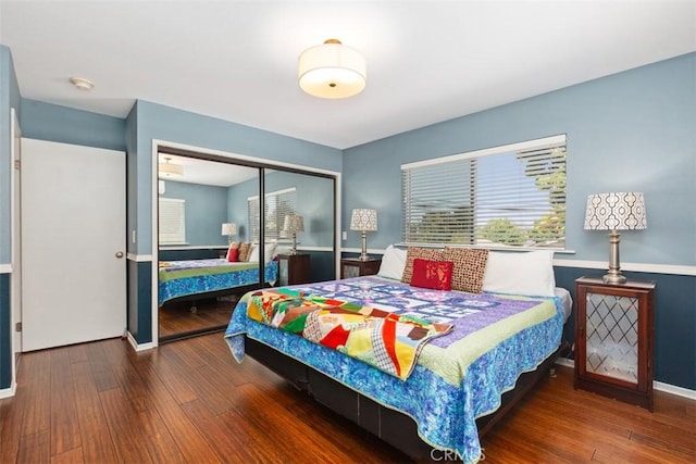 bedroom with dark hardwood / wood-style floors and a closet