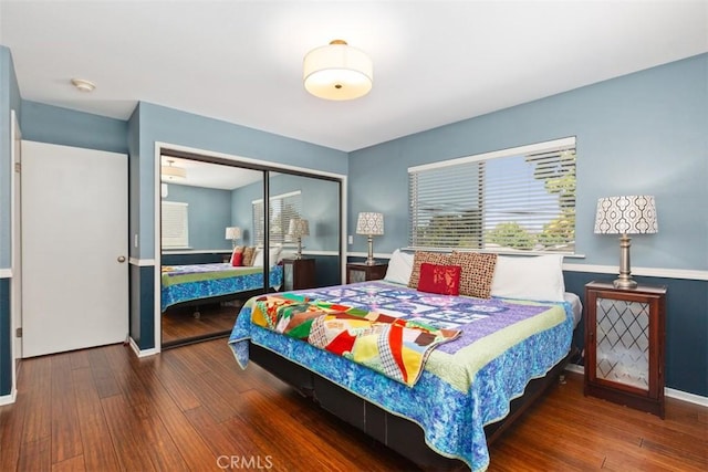 bedroom featuring a closet, baseboards, and dark wood-style flooring