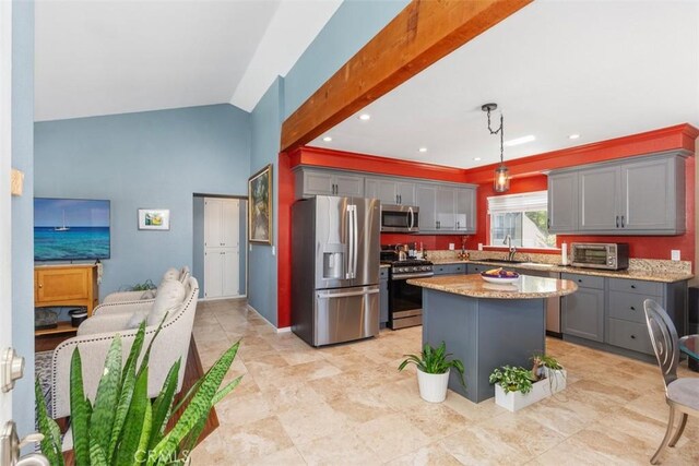 kitchen featuring pendant lighting, lofted ceiling, sink, a kitchen island, and stainless steel appliances