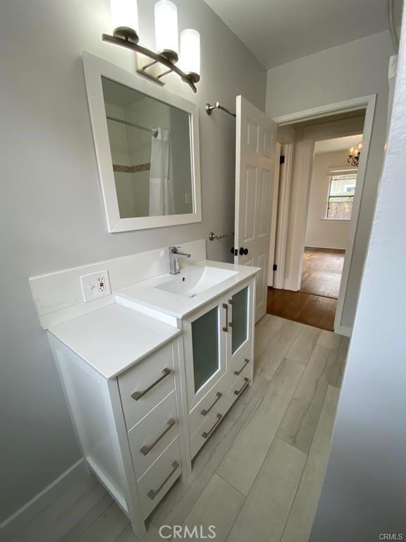 bathroom featuring vanity, wood-type flooring, and an inviting chandelier