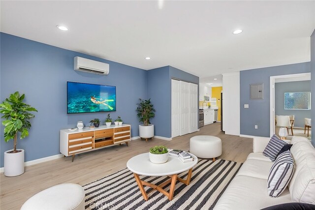 living room featuring an AC wall unit and light wood-type flooring