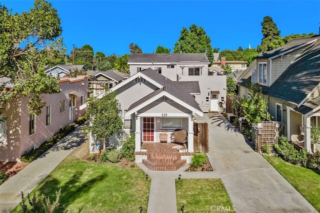 view of front facade featuring a residential view, a front lawn, and stucco siding