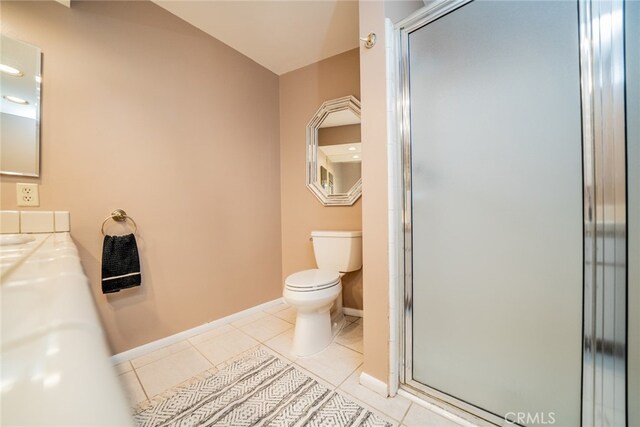 bathroom with vanity, walk in shower, tile patterned flooring, and toilet