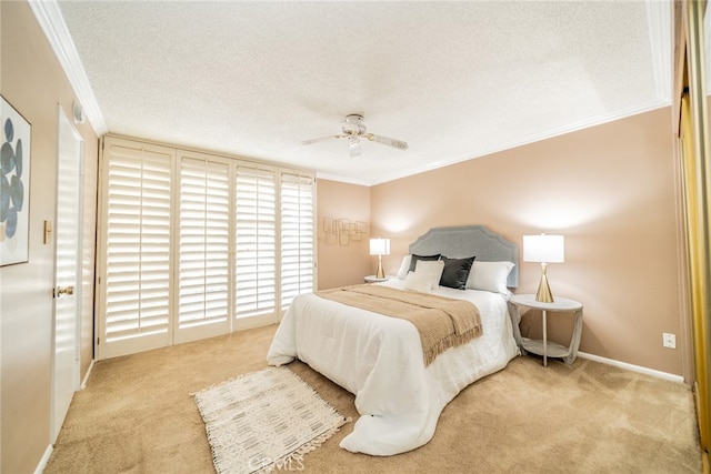 carpeted bedroom featuring a textured ceiling, ceiling fan, and ornamental molding