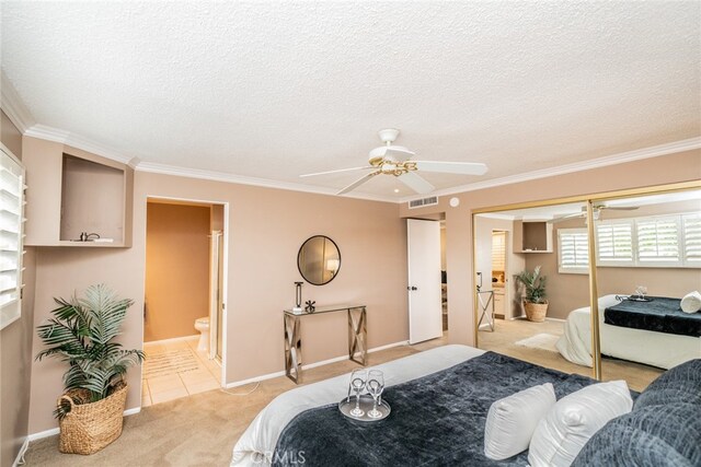 carpeted bedroom featuring a closet, ensuite bath, crown molding, a textured ceiling, and ceiling fan