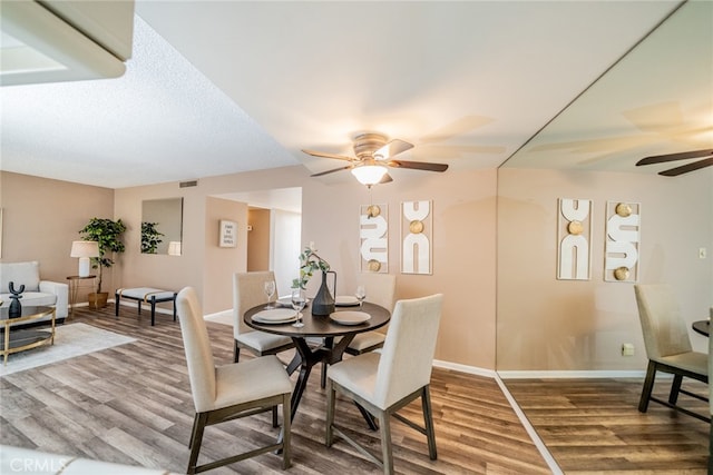 dining space with hardwood / wood-style flooring and ceiling fan