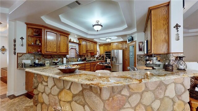 919 Venus Way, Crestline, CA 92325 - kitchen featuring stainless steel fridge, a peninsula, light stone countertops, a tray ceiling, and open shelves