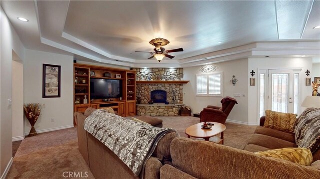 919 Venus Way, Crestline, CA 92325 - carpeted living room featuring a ceiling fan, a tray ceiling, a stone fireplace, and baseboards