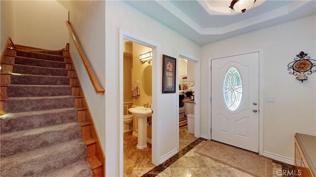 919 Venus Way, Crestline, CA 92325 - entrance foyer with baseboards, stairs, a tray ceiling, and arched walkways