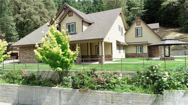 919 Venus Way, Crestline, CA 92325 - view of front of home with a fenced front yard, stone siding, roof with shingles, and a gazebo