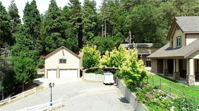 919 Venus Way, Crestline, CA 92325 - exterior space with a garage, fence, driveway, stone siding, and roof with shingles