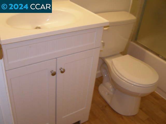 bathroom featuring vanity, wood-type flooring, and toilet