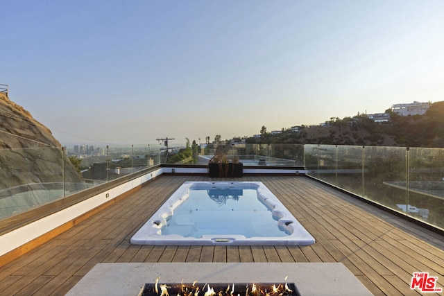 pool at dusk featuring an outdoor fire pit